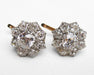A pair of vintage-style diamond cluster stud earrings with a silver-toned setting and gold-toned post backs, displayed on a white textured fabric background.
